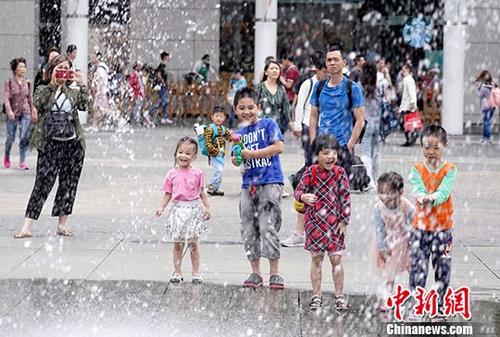 5月2日，小朋友在香港东涌市中心喷泉广场嬉戏。自港珠澳大桥通车以来，每逢内地长假期都有大量内地旅客经大桥抵港游玩，致使连接大桥的香港东涌一带人潮拥挤。一连4天的内地长假期“五一黄金周”自5月1日开始，东涌市中心人流明显较平日增多；但附近居民普遍认为拥挤情况已有改善，并相信与接驳大桥的巴士线路永久搬迁至相对远离民居的位置有关。<a target='_blank' href='http://www.chinanews.com/'>中新社</a>记者 张炜 摄