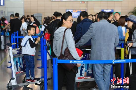 资料图：游客在上海浦东国际机场T1航站楼等待办理登记手续。 殷立勤 摄