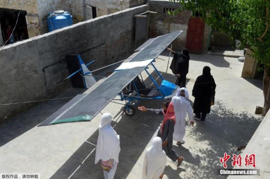 当地时间2019年4月8日，巴基斯坦旁遮普省Tabur，当地村民Muhammad Fayyaz和他自制的“飞机”。该飞机的发动机来自路面切割机，机翼用麻布袋制作，轮子取材三轮车。