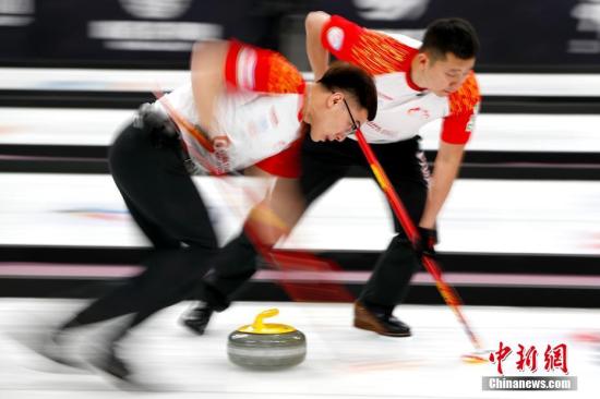 资料图：中国队许静韬(左)、巴德鑫在比赛中擦刷冰面。<a target='_blank' href='http://www.chinanews.com/'>中新社</a>记者 富田 摄