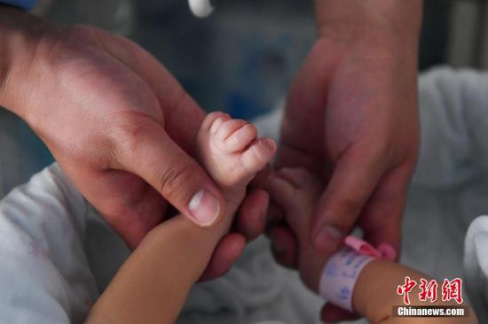 资料图：护士给新生儿进行抚触操作。 /p中新社记者 任东 摄