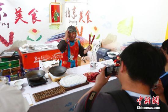 5月16日，亚洲美食节在北京奥林匹克公园中心区设置的主会场迎客，该美食节是亚洲文明对话大会的重要配套活动。图为北京传统叫卖吸引观众。<a target='_blank' href='http://www.chinanews.com/'>中新社</a>记者 富田 摄