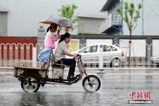 资料图：民众在雨中出行。<a target='_blank' href='http://www.chinanews.com/'>中新社</a>记者 张兴龙 摄