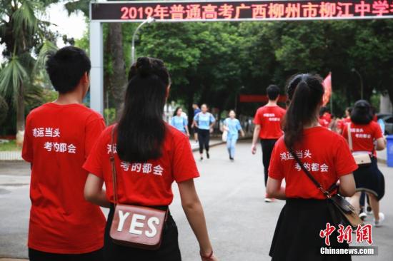 6月7日，2019年高考启幕。在广西柳州市柳江中学考点，考生们头戴红绳、穿着印有“鸿运当头考的都会”字样的衣服、举着“必胜，加油”的牌子，一路唱着歌步入考场，以各式各样的方式为自己鼓劲加油。今年广西高考考生规模达46万，较去年增幅6万余人，总报考人数再创历史新高。图为高考生穿着印有“鸿运当头考的都会”字样的衣服。朱柳融 摄