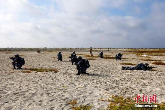 三沙中建岛孤悬于西沙群岛西南端，处在远东通往东南亚的海空要道之上，北距海南岛三百余公里。“没有七分英雄胆，休上中建白沙滩。”在中建岛，记者试图通过盘点驻岛官兵们的绰号，来探究这群中建硬汉的“英雄本色”。图为战士们在白沙滩上进行军事训练。王晓斌 摄