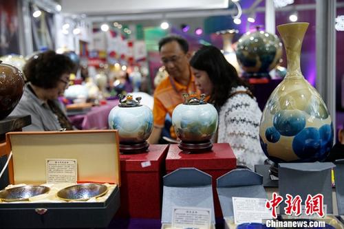 资料图：在哈尔滨举行的第六届中国-俄罗斯博览会上，参观者挑选台湾陶瓷工艺品。<a target='_blank' href='http://www.chinanews.com/'><p class=