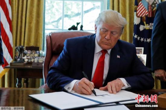 资料图：2019年6月24日，美国总统特朗普在白宫椭圆形办公室展示签署的行政令，对伊朗最高领袖哈梅内伊及其领导下的机构实施制裁。