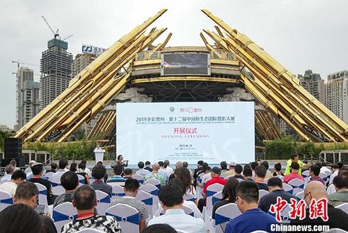 资料图:6月29日,2019多彩贵州·第十二届中国原生态国际摄影大展在贵阳开展,1500幅精选作品呈现出一个篆体“贵”字,展现了贵州原生态自然风光、民族文化和70年来的发展成就。图为开展仪式现场。 中新社记者 贺俊怡 摄 资料图:6月29日,2019多彩贵州·第十二届中国原生态国际摄影大展在贵阳开展,1500幅精选作品呈现出一个篆体“贵”字,展现了贵州原生态自然风光、民族文化和70年来的发展成就。图为开展仪式现场。 中新社记者 贺俊怡 摄