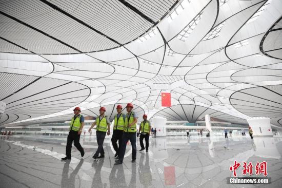 6月30日，北京大兴国际机场航站区工程竣工验收。大兴国际机场建设工程历时4年，拥有世界上规模最大、施工难度最高的单体航站楼，预计9月底正式通航，与之相配套的高铁、机场快轨线、高速公路也将同步开通运营。届时，北京大兴国际机场将成为中国最大的综合立体交通枢纽。图为6月26日，工作人员在航站楼内巡视。 /p中新社记者 赵隽 摄