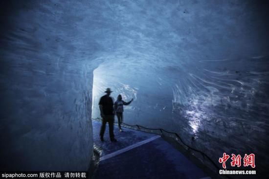 资料图：法国夏蒙尼，游客参观勃朗峰冰川下的冰洞。图片来源：Sipaphoto版权作品 禁止转载