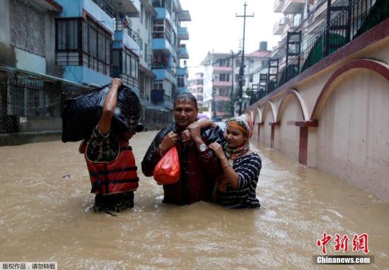 资料图：当地时间7月12日，尼泊尔加德满都，当地迎来雨季，城区街道被雨水淹没，居民出行困难，当地派出军人确保居民安全。