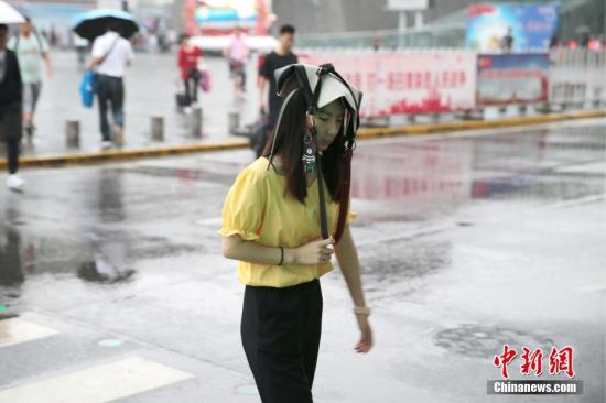 7月17日，陕西关中地区迎来降雨天气，预计降雨持续3日。据陕西省气象台消息，西安自六月中下旬以来至今，是同时期36年来最凉快的一个时段。图为西安民众雨中出行。<a target='_blank' href='http://www.chinanews.com/'>中新社</a>记者 张远 摄