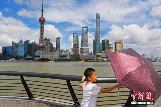 资料图：孩子拿着伞在外滩滨江步道上玩耍。殷立勤 摄