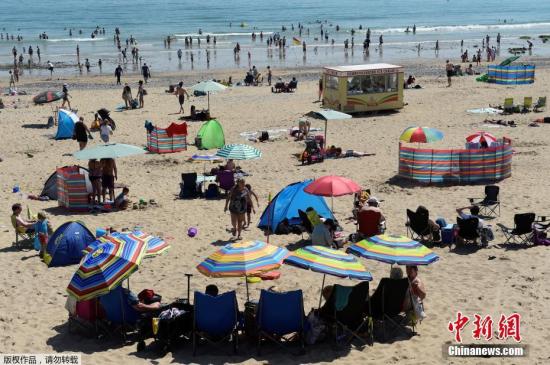 当地时间2019年7月23日，英国威尔士，当地迎高温天气，民众到海滩享受休闲时光。