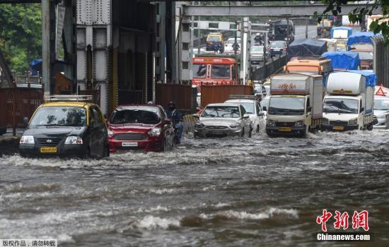 当地时间7月24日，印度孟买，大雨过后，街道被洪水淹没，人们出行不便。