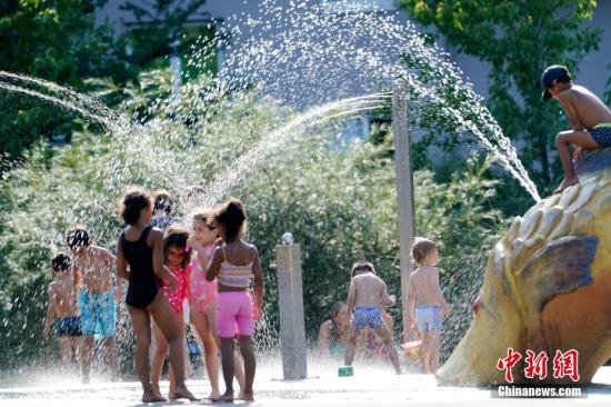 7月25日，席卷整个欧洲的极端高温天气使德国连续两天刷新最高气温纪录。柏林市中心一处公园内，儿童在喷泉周围享受清凉。/p中新社记者 彭大伟 摄