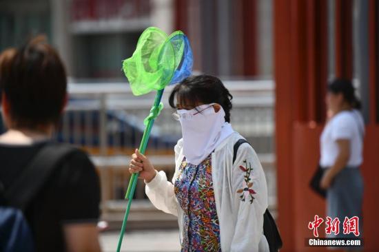 8月1日，北京高温天气持续，出行的市民用各种装备来遮挡炙热的阳光。<a target='_blank' href='http://www.chinanews.com/'>中新社</a>记者 张兴龙 摄
