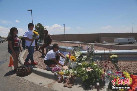 当地时间8月4日，美国埃尔帕索民众走上街头，向枪击案受害者表达哀悼。图为人们在案发地沃尔玛超市边摆放献花表达哀悼。/p中新社记者 曾静宁 摄