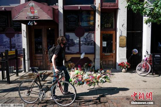 资料图：美俄州代顿民众悼念枪击案遇难者，事发地的酒吧前摆满鲜花。
