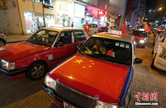 资料图：8月23日晚，“守护香港大联盟”联同香港的士司机从业员总会发起“守护香港·风雨同舟”大行动，在港岛筲箕湾中心，有超过140多辆出租车车身贴着海报，车尾悬挂五星红旗依次有序驶向主干道，呼吁社会反对暴力。<a target='_blank' href='http://www.chinanews.com/'>中新社</a>记者 张炜 摄