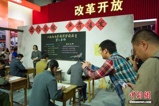 9月24日，“伟大历程 辉煌成就――庆祝中华人民共和国成立70周年大型成就展”在北京展览馆向公众开放。图为“恢复高考”场景展区吸引参观者。记者 侯宇 摄