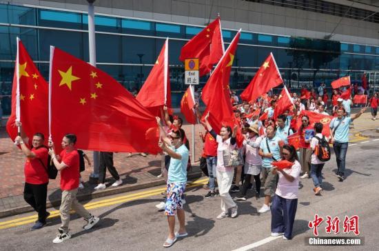 10月1日国庆节，众多香港市民挥舞五星红旗来到金紫荆广场，欢庆国庆节，庆祝祖国70岁华诞。一路上他们高喊“中国加油”、“祖国万岁”、“生日快乐”等口号，并高唱国歌和《歌唱祖国》等爱国歌曲。<a target='_blank' href='http://www.chinanews.com/'>中新社</a>记者 张炜 摄