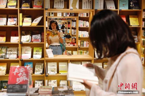10月3日，市民在上海爱琴海购物公园的新华书店内看书。国庆假期里，民众利用长假“充电”，在书香中享受假期的悠闲。/p中新社记者 殷立勤 摄