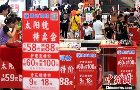 资料图为厦门市民在商场选购打折促销商品。<a target=