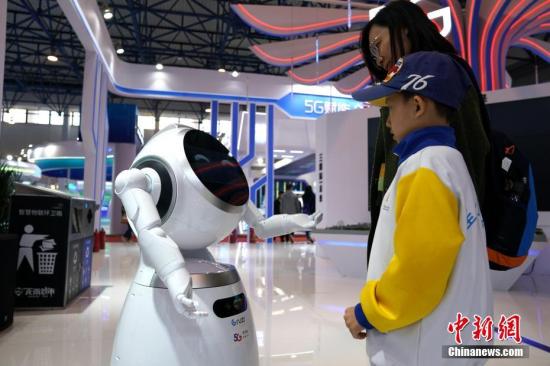 资料图：小男孩与智能机器人“对话”。<a target='_blank' href='http://www.chinanews.com/'>中新社</a>记者 张兴龙 摄