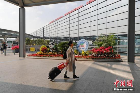 11月3日，第二届中国国际进口博览会即将开幕，上海的各个重要场所进博会氛围浓厚。图为旅客从虹桥机场T2航站楼进博会景观前走过。殷立勤 摄