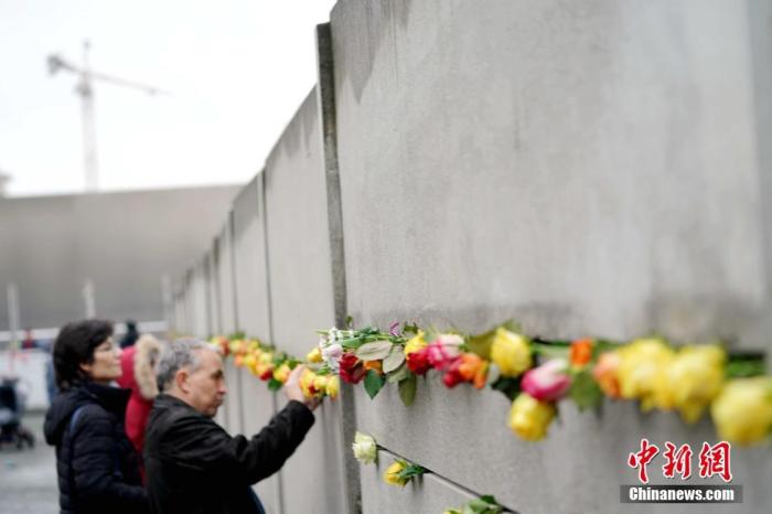 资料图：2019年11月9日是柏林墙倒塌30周年纪念日，当天在德国首都柏林等地举行了多种纪念活动。图为游人当天在主要纪念场所之一、柏林火车北站外的柏林墙遗址纪念公园内一面插满玫瑰花的柏林墙遗迹前拍照留念。<a target='_blank' href='http://www.chinanews.com/'>中新社</a>记者 彭大伟 摄
