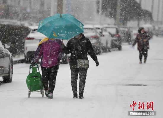 资料图：市民在街头冒雪出行。张瑶 摄