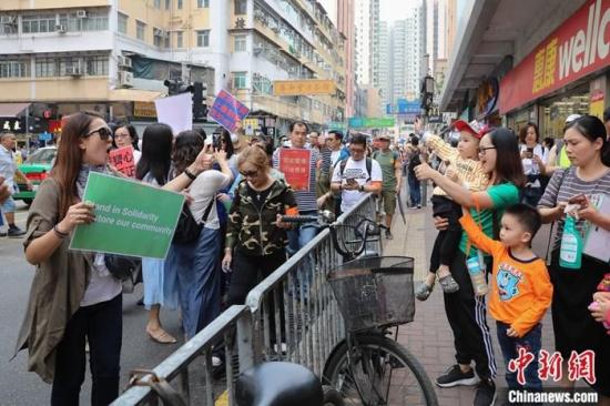 11月14日，数百香港市民在元朗举行“别沉默 企出来 香港需要你”游行集会，支持警察严正执法。图为沿途有不少市民点赞鼓掌，并不断有市民加入游行队伍。<a target='_blank' href='http://www.chinanews.com/'>中新社</a>记者 谢光磊 摄