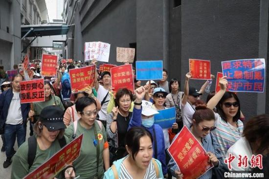 11月14日，数百香港市民在元朗举行“别沉默 企出来 香港需要你”游行集会，支持警察严正执法。市民从元朗地铁站出发，手臂挂上“香港好市民”的臂章，高举“支持一国两制”、“政府齐心 拨乱反正”等标语，呼喊“支持警察 严正执法”等口号，游行至元朗警署对面的球场。<a target='_blank' href='http://www.chinanews.com/'>中新社</a>记者 谢光磊 摄