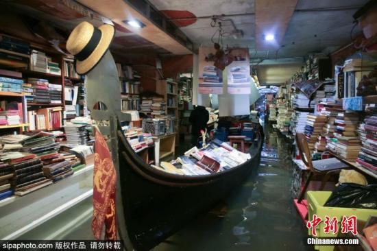 11月16日，意大利，威尼斯著名书店“沉船书店”(Acqua Alta Libreria)遭洪水侵袭，志愿者们将损坏的书籍堆积起来。近日，意大利著名旅游城市威尼斯遭遇暴雨袭击并引发洪水。意大利政府14日宣布，正遭受洪灾侵袭的意大利古城威尼斯进入紧急状态。图片来源：Sipaphoto 版权作品 禁止转载