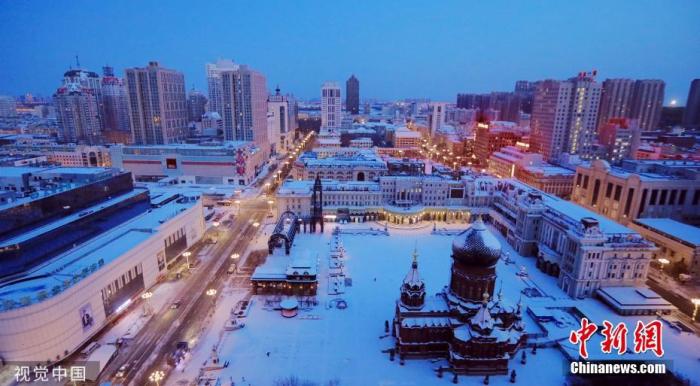 11月18日，中央气象台继续发布寒潮蓝色预警。预计，18日至19日，内蒙古东北部、黑龙江北部等地有大雪。强冷空气继续影响我国东部地区，多地有大风降温天气。图为11月18日，黑龙江哈尔滨大雪过后的索菲亚广场。图片来源：视觉中国
