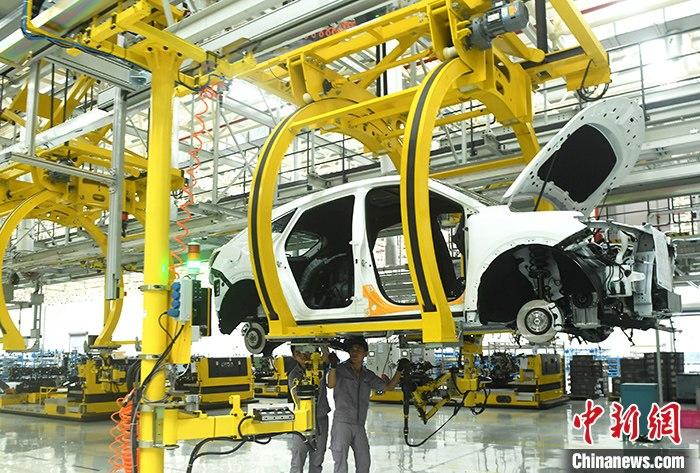 资料图为重庆一汽车生产车间内的工作人员正在组装车辆。 中新社记者 陈超 摄