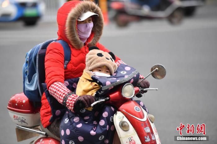 资料图：民众着厚重的冬装出行。中新社记者 刘冉阳 摄
