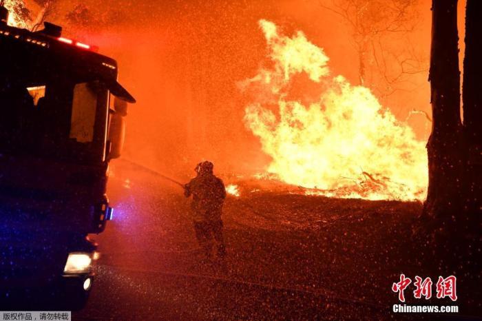 资料图：当地时间2019年12月3日，澳大利亚新南威尔士州Kioloa附近，当地山区野火持续燃烧，消防人员深夜救火。