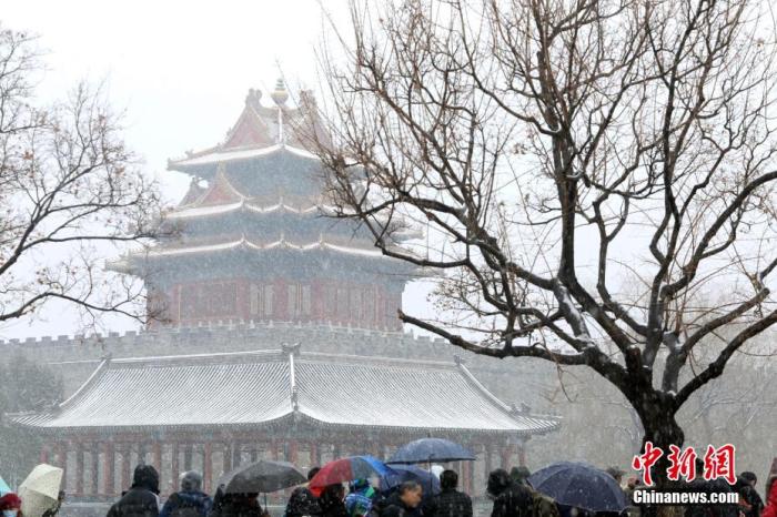 12月16日，游客在北京故宫角楼欣赏雪景。当日，北京迎来今冬第二场雪，故宫角楼银装素裹，美不胜收。 /p中新社记者 蒋启明 摄