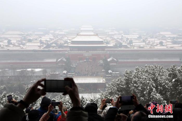 12月16日，游客欣赏雪后故宫。当日，北京迎来今冬第二场雪，故宫银装素裹，美不胜收。 中新社记者 蒋启明 摄