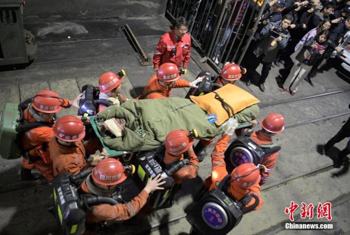 资料图：被困矿工由救援人员用担架抬出，随后被救护车送往当地医院。中新社记者 刘忠俊 摄