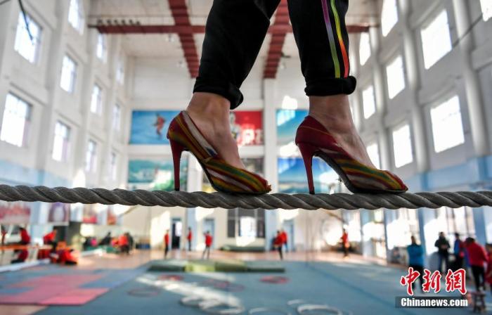 资料图：学员脚穿高跟鞋在低空绳索上行走，苦练达瓦孜技艺。中新社记者 刘新 摄