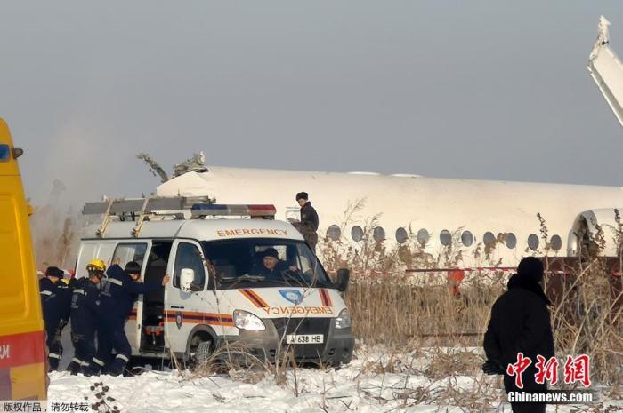 当地时间12月27日，哈萨克斯坦BEK AIR航空公司一架载有100人的飞机在阿拉木图附近坠毁。图为几名救护人员聚集在一辆停在现场的急救车旁。