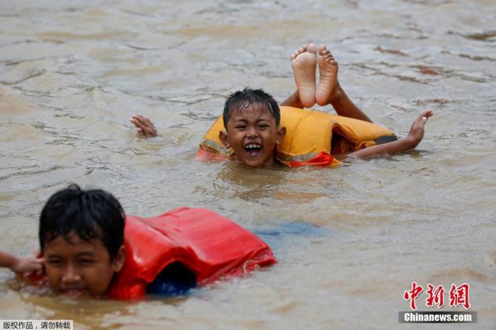 当地时间1月2日，印尼首都雅加达遭遇暴雨，雨后城市街道洪涝严重，大人忙着转移家中财务，孩子们在水中嬉戏玩耍，丝毫没有因为洪水影响心情。