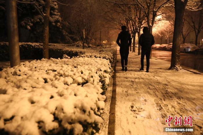 1月5日晚，北京迎来2020年第一场雪。图为民众冒雪出行。中新社记者 赵隽 摄
