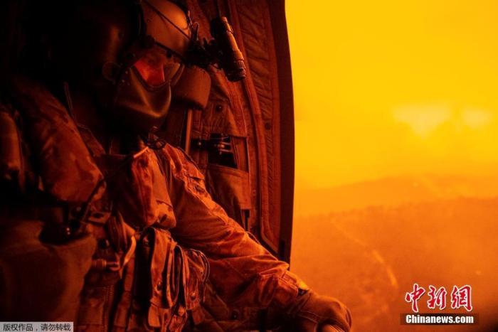 当地时间1月4日，澳大利亚陆军第5航空中队的2级准尉达雷尔·罗参与“林火救援”行动期间，乘坐CH-47F奇努克号机飞维多利亚州奥米奥。他们的将从这里撤走当地平民，然而空气中弥漫的昏黄气体无疑增加了任务的难度。澳大利亚山林野火从2019年9月开始零星出现，至今已延烧了近4个月。
