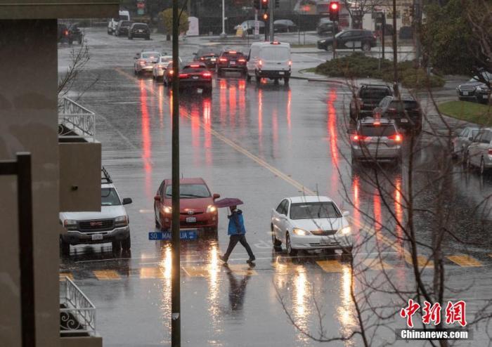 当地时间1月16日，美国加利福尼亚州旧金山湾区的行人在暴雨中前行。 <a target='_blank' href='http://www.chinanews.com/'>中新社</a>记者 刘关关 摄