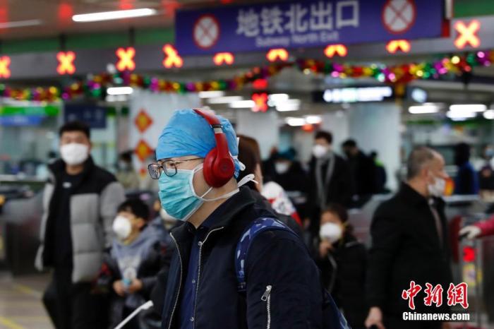 1月23日，北京西火车站迎春运客流高峰，旅客佩戴口罩乘车。/p中新社记者 韩海丹 摄