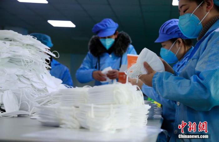 资料图：1月24日，上海郊区奉贤一家专业生产KN95口罩的工厂内，工人加班加点生产口罩。新型冠状病毒感染的肺炎疫情扩散，防护口罩成为紧俏商品，市场需求陡然上涨，一时间供不应求。上海的口罩生产厂家，召回技术骨干和部分工人，并聘请临时工，春节假期开启全天候生产模式。劳作了一年的外来务工人员，或放弃与家人团聚，或从家中即刻返回。<a target='_blank' href='http://www.chinanews.com/'>中新社</a>记者 汤彦俊 摄